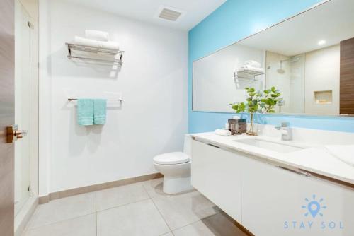 a bathroom with a sink and a toilet and a mirror at Best Stay - Rooftop Pool & Hot Tub - Hollywood Beach in Hollywood