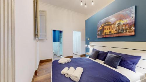 a bedroom with a large blue bed with two towels on it at Ai Crociferi affittacamere in Palermo