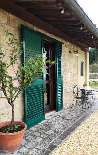 a house with a green door and a table at Podere Campiano in Volterra