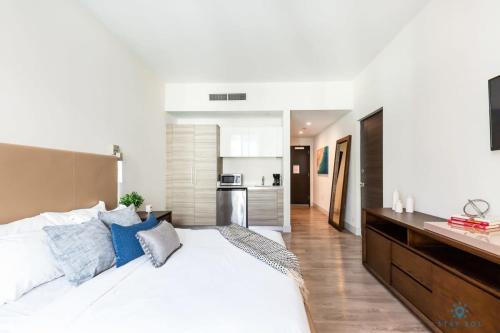 a bedroom with a large white bed with blue pillows at Amazing Pool - Gym - Hot Tub - Near Beach in Hollywood