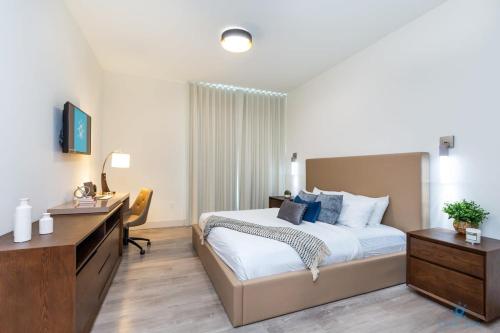 a bedroom with a bed and a dresser and a desk at Amazing Pool - Gym - Hot Tub - Near Beach in Hollywood