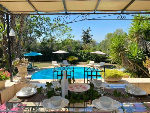 - une table avec des assiettes et des bols à côté d'une piscine dans l'établissement La porte du Soleil, à Bagnols-en-Forêt