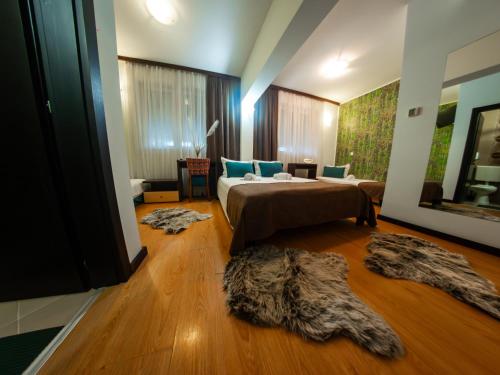 ein Schlafzimmer mit einem Bett und zwei Teppichen auf dem Boden in der Unterkunft Motel Krnjevo in Krnjevo