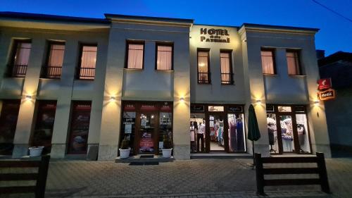 una tienda frente a un edificio con muchas ventanas en Hotel Patonai en Fertőd