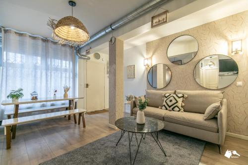 a living room with a couch and a table and mirrors at MBA - Splendide Appartement Proche Montmartre in Paris