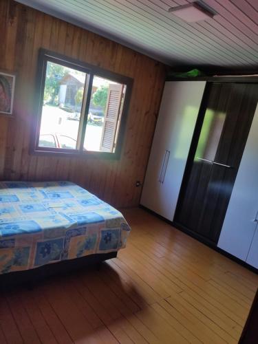 um quarto com uma cama, uma janela e uma porta em Sitio em Maquiné