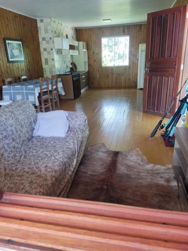 uma sala de estar com uma cama e uma cozinha em Sitio em Maquiné