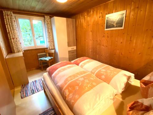um quarto com uma cama num quarto com paredes de madeira em Haus Mangard em Sankt Gallenkirch