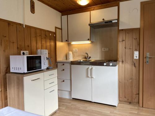 uma cozinha com um frigorífico branco e um micro-ondas em Haus Mangard em Sankt Gallenkirch