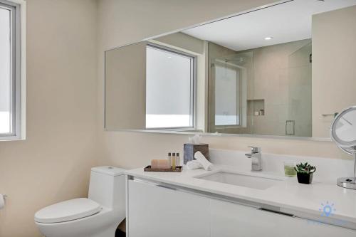 ein Badezimmer mit einem WC und einem großen Spiegel in der Unterkunft Rooftop Pool - Balcony - Hollywood Beach - Gym in Hollywood