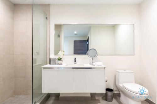 uma casa de banho com um WC, um lavatório e um espelho. em Perfect Relax - Rooftop Pool - Gym - Hot Tub em Hollywood