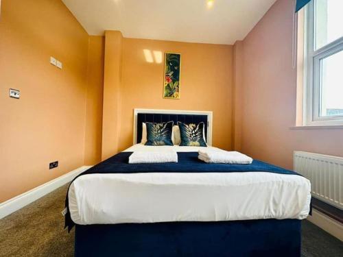 1 dormitorio con 1 cama grande y paredes de color naranja en one bedroom sleep 3 Near station en Brighton & Hove