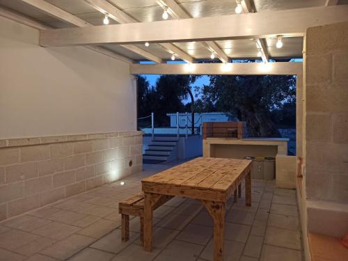 a patio with a wooden table and lights on it at Italianway - Villa Butticchio in Serranova