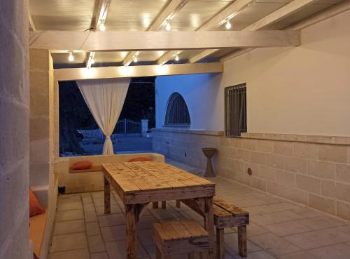 eine Terrasse mit einem Tisch, einer Bank und Lampen in der Unterkunft Italianway - Villa Butticchio in Serranova