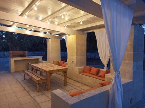 eine Terrasse mit einem Holztisch und einer Bank in der Unterkunft Italianway - Villa Butticchio in Serranova