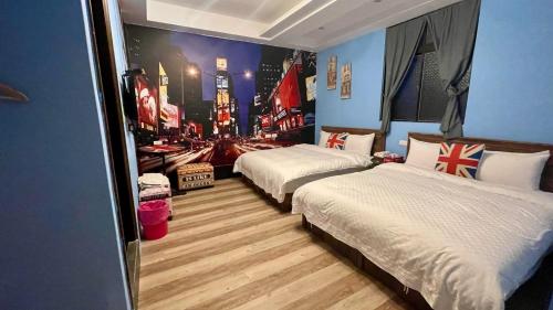 two beds in a room with a city scene on the wall at Honey House in Luodong