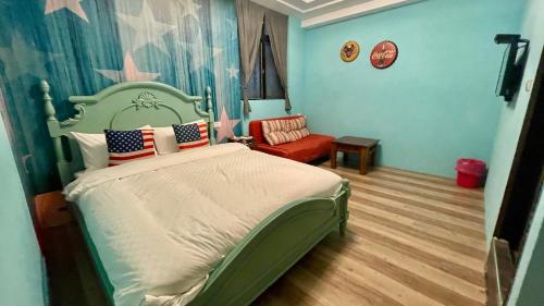 a bedroom with a bed and a red chair at Honey House in Luodong