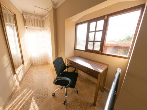 Habitación con escritorio, silla y ventana. en Casa Martinez en Sucre