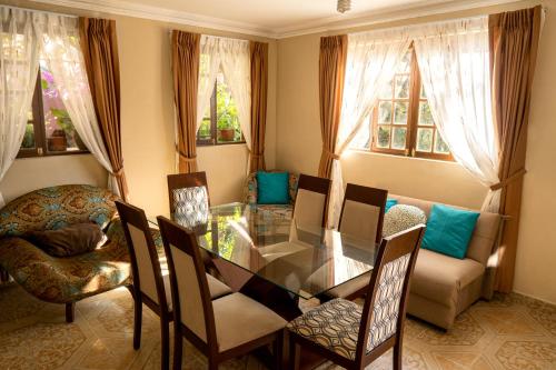 a dining room with a glass table and chairs at Casa Martinez in Sucre