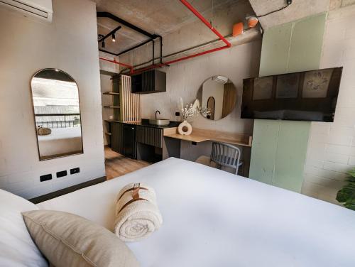 Urbit Social Lofts في ميديلين: غرفة نوم بسرير ابيض ومطبخ