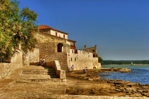 an old stone building next to a body of water at RIVALMARE Beach Boutique Hotel - NEW! in Novigrad Istria