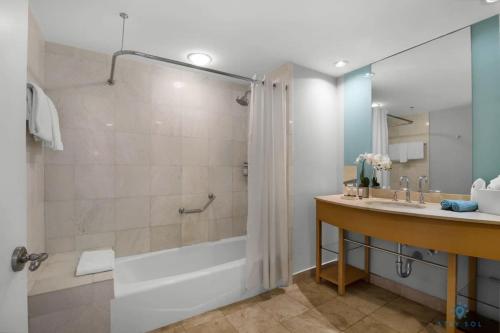 y baño con bañera, lavamanos y ducha. en New Sunny Isles Retreat: Oceanview Comfort en Aventura
