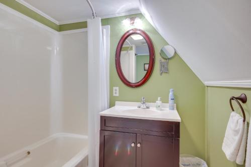a bathroom with a sink and a mirror and a tub at Aiken Apt with Garden-View Balcony Half-Mi to Dtwn! in Aiken
