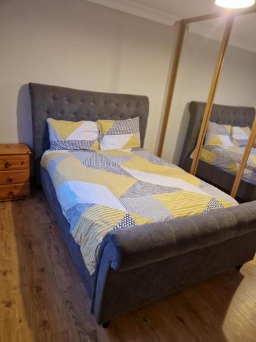 a bed with a blue and yellow comforter in a bedroom at Radharc Na Mara in Letterkenny