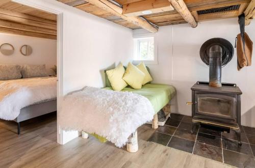 a bedroom with a bed and a wood stove at L'Oasis Zen bord de L'eau & Spa in Nominingue