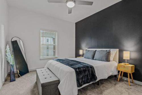 Un dormitorio con una cama grande con una pared de acento negro en Sleek Modern Gateway 10 Min to Parks Pets Allowed, en Orlando