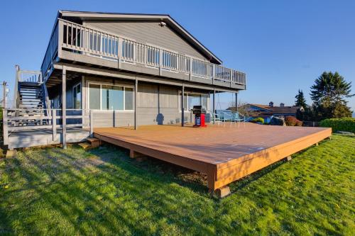 a house with a large wooden deck in the yard at Scenic Tacoma Apartment with Deck and Fire Pit! in Tacoma