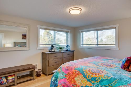 a bedroom with a bed and a dresser and two windows at Scenic Tacoma Apartment with Deck and Fire Pit! in Tacoma