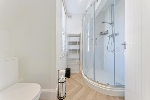 a white bathroom with a shower and a toilet at City Centre Riverside Retreat in Kent