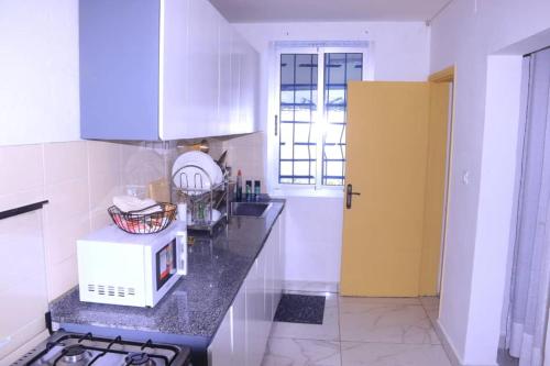 eine Küche mit einer Arbeitsplatte und einer Mikrowelle in der Unterkunft Résidence reine lumière in Libreville