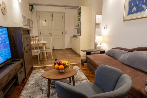 sala de estar con sofá y mesa con un bol de fruta en Little Vienna Silver Apartment, en Varaždin