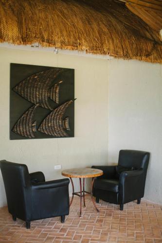 two chairs and a table in a room with a painting at Cuna Mangodlong Paradise Beach Resort in Camotes Islands