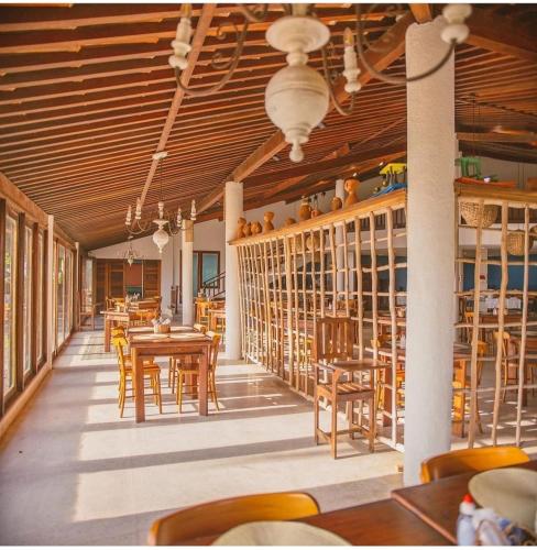a dining room with wooden tables and chairs at Angá Beach Hotel in São Miguel dos Milagres