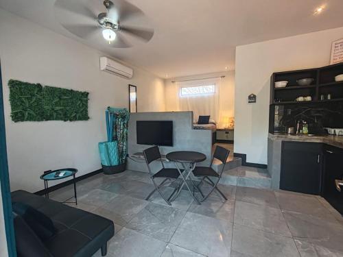 - un salon avec un canapé et une table avec des chaises dans l'établissement Casa Adams - Apartamentos Adams, à Tamarindo
