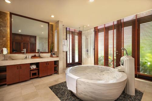 a large bathroom with a large tub and two sinks at Abogo Champa Villa Beach Da Nang in Da Nang