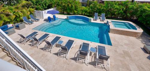 an overhead view of a swimming pool with chairs and a swimming pool at 2BR Near The Beach !Walk 2 Everything! in West Palm Beach