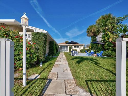 a house with a pathway leading to a yard at 2BR Near The Beach !Walk 2 Everything! in West Palm Beach