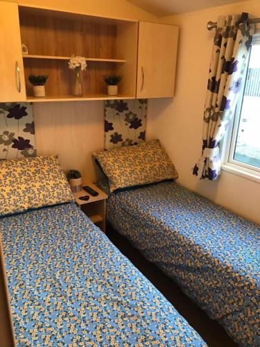a bedroom with two beds and a window at Lyons Robin Hood Rhyl North wales six berth caravan choice of two available in Meliden