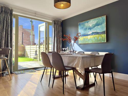 a dining room with a table and chairs and a large window at Grange Garth near the river in York
