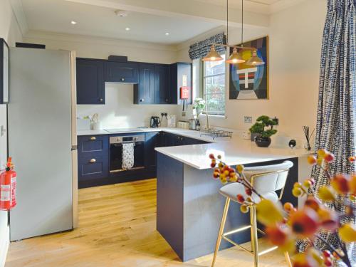 a kitchen with blue cabinets and a white counter top at Grange Garth near the river in York