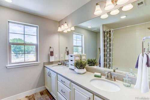 La salle de bains est pourvue de 2 lavabos et d'un grand miroir. dans l'établissement Stunning Golf Course View in Denver, à Denver