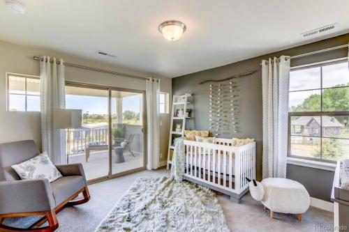 - une chambre bébé avec un lit bébé, une chaise haute et une fenêtre dans l'établissement Stunning Golf Course View in Denver, à Denver