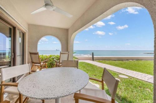 a patio with a table and chairs and the ocean at George Town Villas 118 in George Town