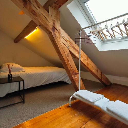 a attic room with a bed and a staircase at Maison de charme au cœur de Genève ! in Geneva