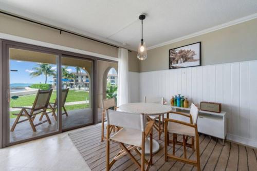 a dining room with a table and chairs and the ocean at George Town Villas 118 in George Town