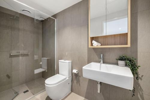 a bathroom with a white toilet and a sink at Urban Elegance Stature Southbank in Melbourne